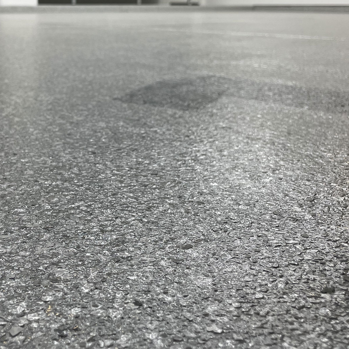 Garage flooring showcasing a polished, textured surface, emphasizing durability and aesthetic appeal for garage transformations by Gear Up Garage.