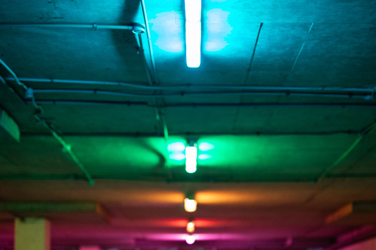 Colorful LED lighting illuminating a garage ceiling, showcasing vibrant hues of green, blue, and pink, reflecting the modern aesthetic of Gear Up Garage transformations.