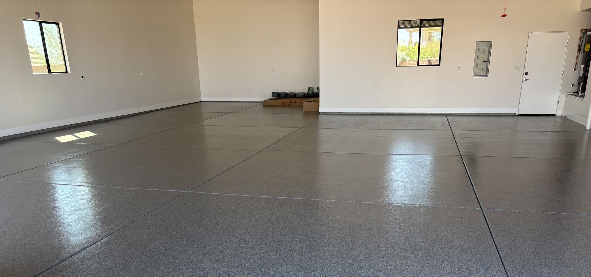 Spacious, freshly renovated garage interior with clean, durable flooring and natural light from windows, showcasing Gear Up Garage's commitment to high-quality makeover solutions.