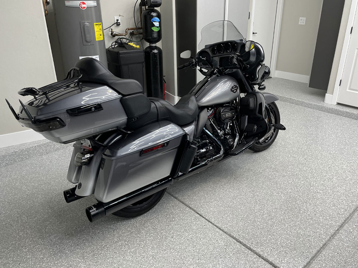 Motorcycle parked in a modern garage with polished flooring, showcasing Gear Up Garage's quality craftsmanship and organized space.