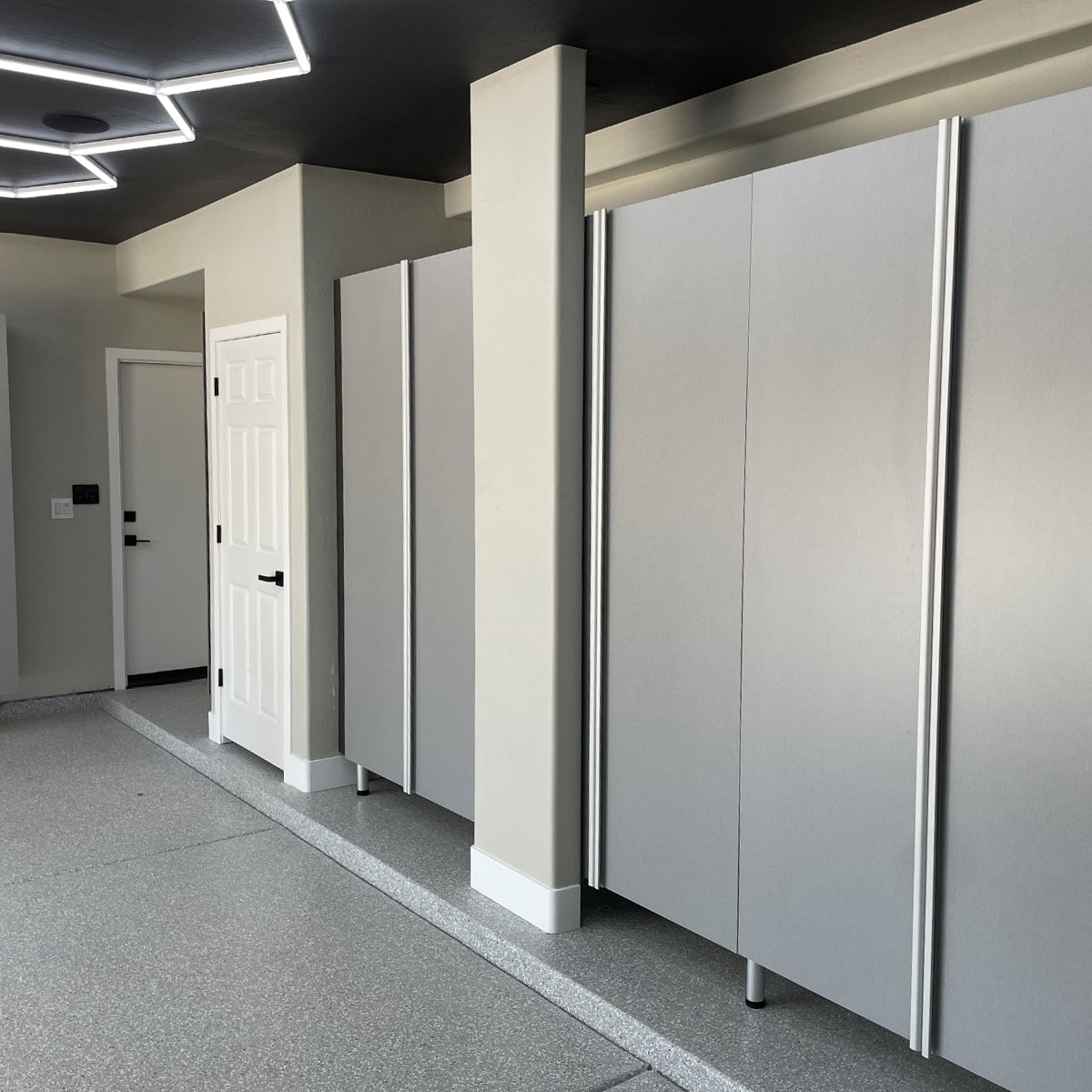 Custom garage cabinetry with sleek gray panels and modern door, enhancing organization and storage solutions in Arizona homes.