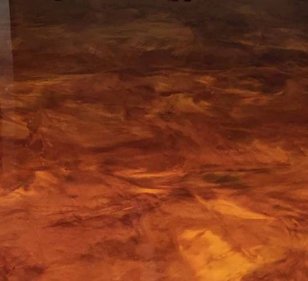 Epoxy flooring in warm tones, showcasing a durable and stylish surface for garage transformations by Gear Up Garage.