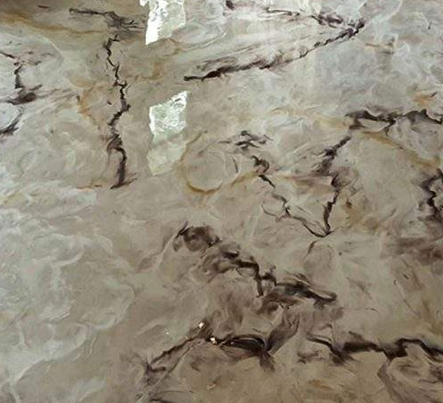 Durable epoxy flooring with a marbled design, showcasing a blend of gray and brown tones, reflecting light and enhancing garage aesthetics.