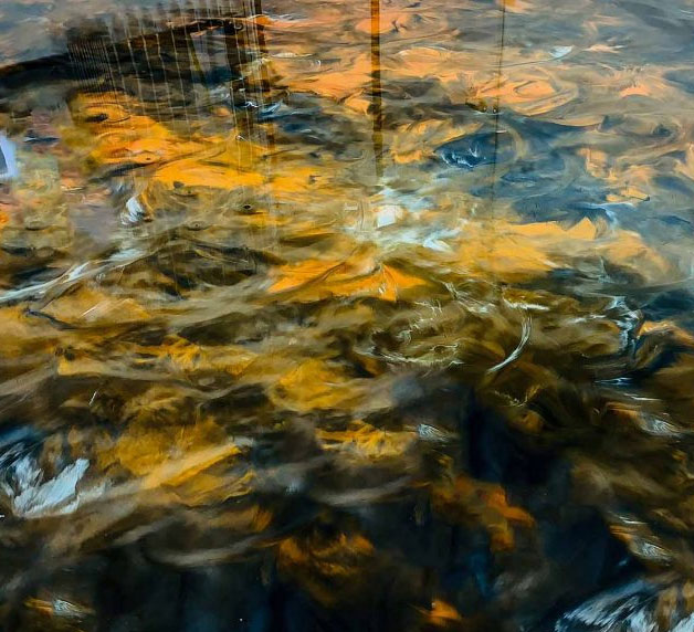 Epoxy flooring with abstract patterns reflecting light, showcasing durability and aesthetic appeal for garage transformations by Gear Up Garage.